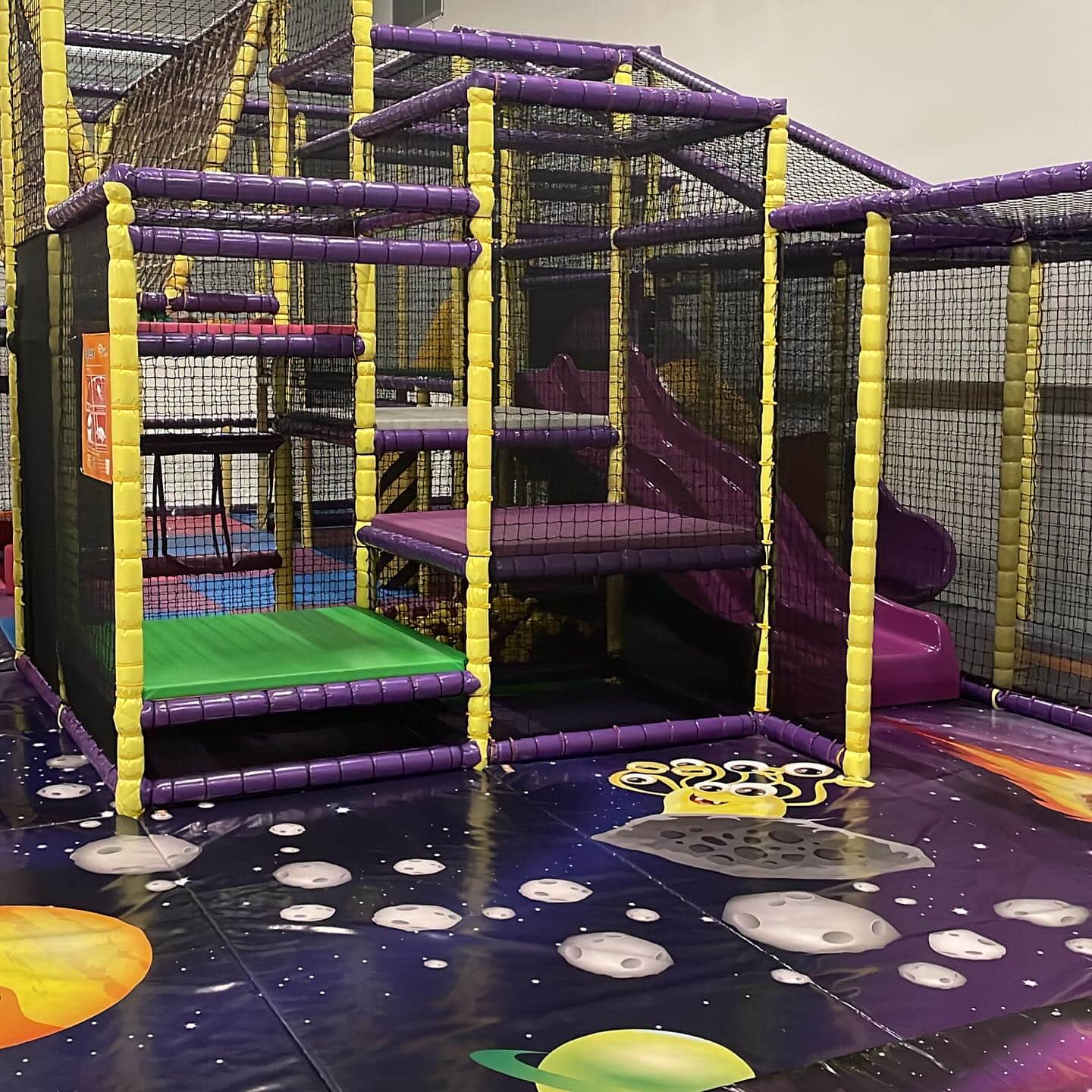 Rolig klätterställning och rutchkana i trampolinpark lekland