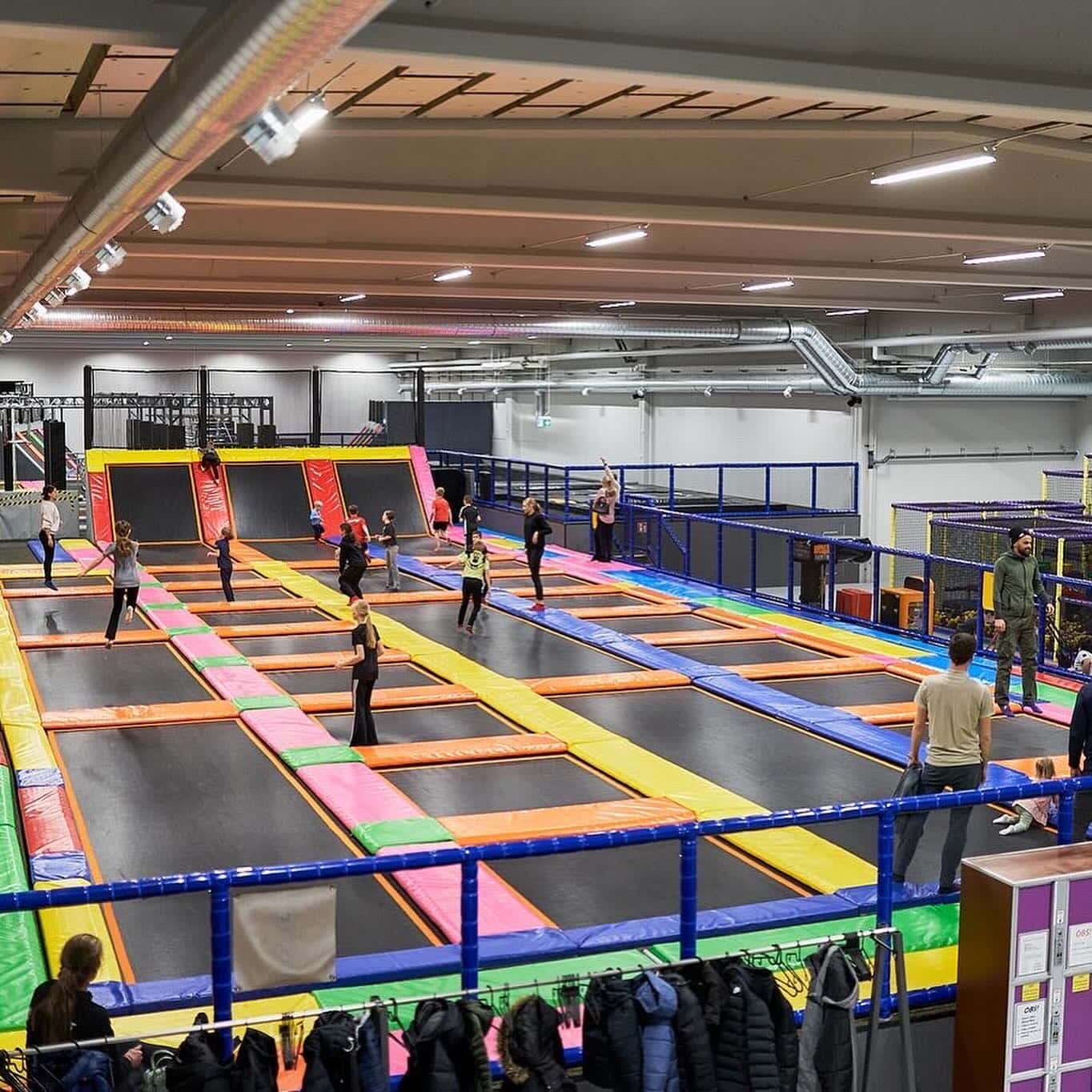 Ungdomar som hoppar i färgglad trampolinpark lekland